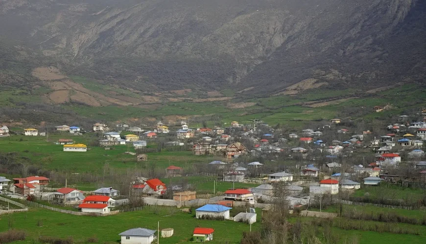 نمای هوایی از خانه‌های روستای داماش در دل کوه‌های البرز با سقف‌های رنگی.